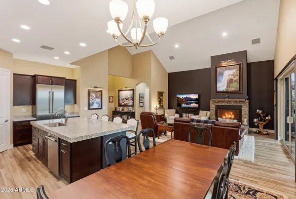 a large kitchen with stainless steel appliances a stove center island a dining table and chairs