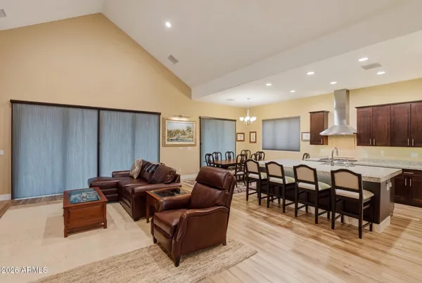 a living room with furniture kitchen view and a wooden floor