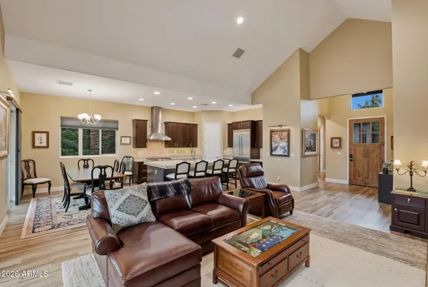 a living room with furniture kitchen view and a large window