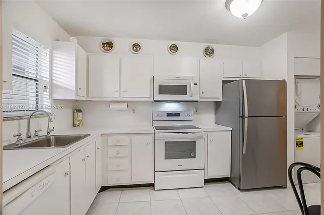 a kitchen with stainless steel appliances granite countertop a refrigerator sink and stove