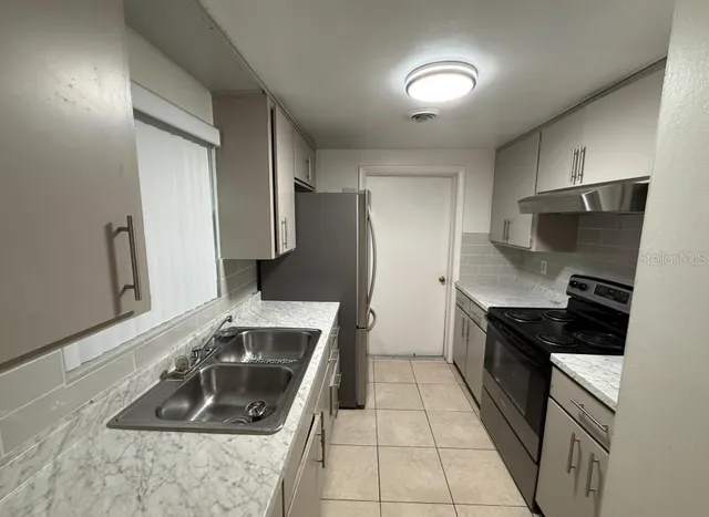 a kitchen that has a sink and a stove in it