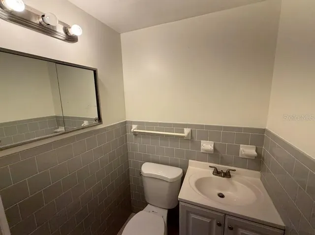 a bathroom with a sink mirror and toilet