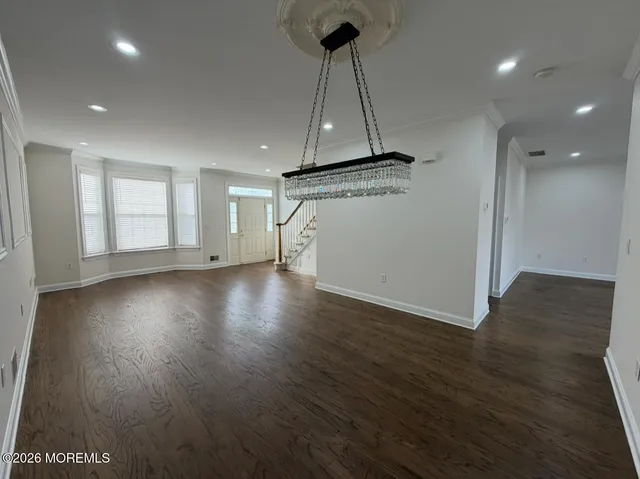 a view of a room with wooden floor and a ceiling fan