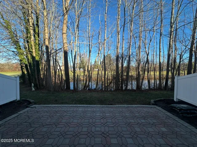 a view of backyard with white fence