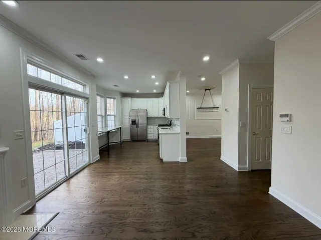 a view of a kitchen with refrigerator and windows