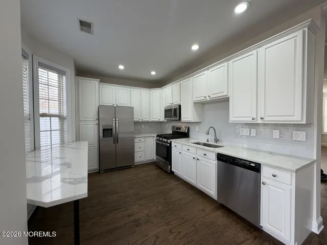a kitchen with stainless steel appliances granite countertop a refrigerator sink and cabinets