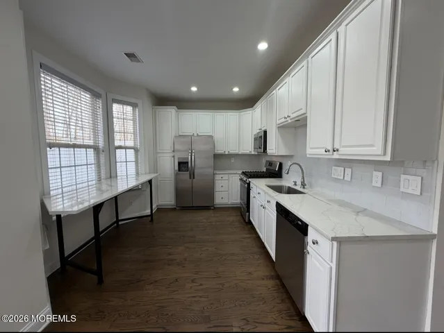 a kitchen with stainless steel appliances granite countertop refrigerator sink and cabinets