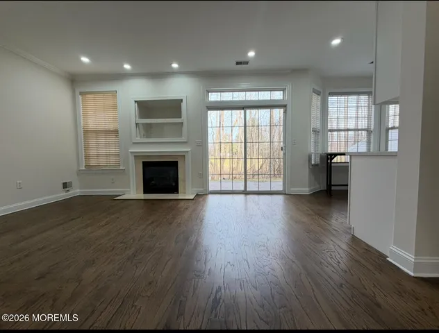 an empty room with wooden floor and fireplace
