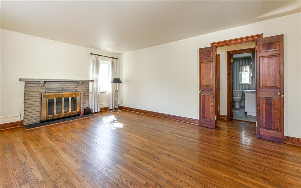 2065 Fairhill Road Sewickley, PA 15143 - Photo 7 of 45 an empty room with wooden floor fireplace and windows