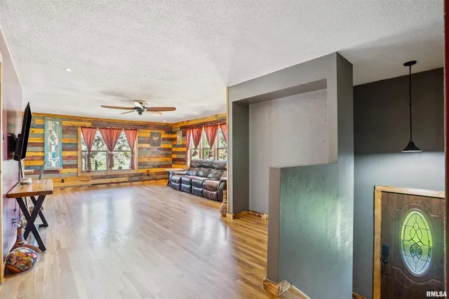 a view of a livingroom with wooden floor and a ceiling fan