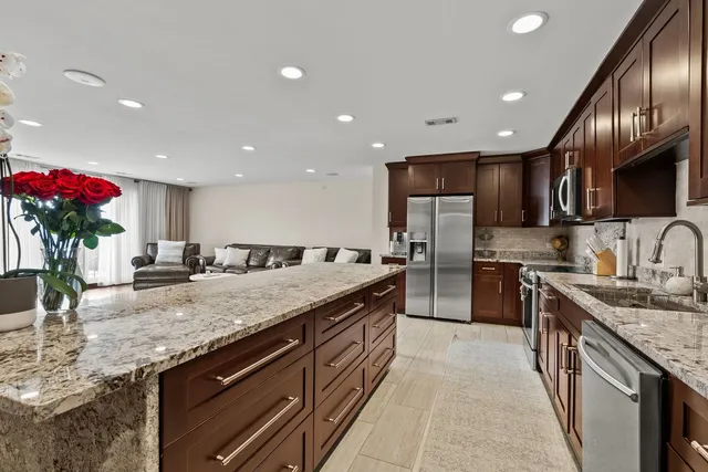 a kitchen with stainless steel appliances granite countertop a sink stove and cabinets