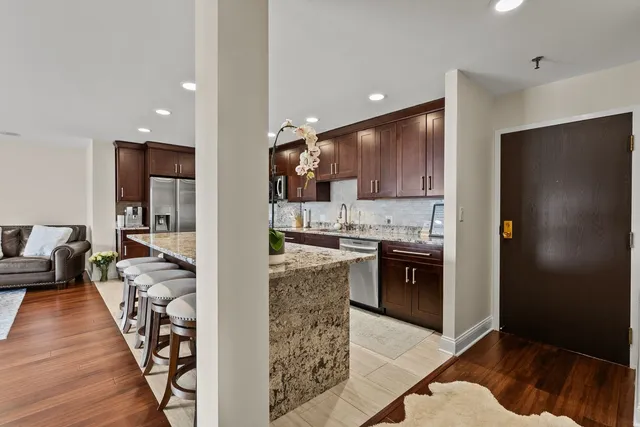a kitchen with stainless steel appliances granite countertop a refrigerator and a stove top oven