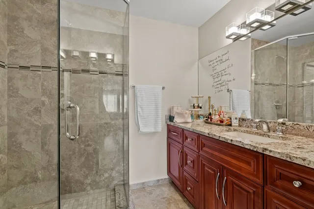 a bathroom with a granite countertop shower sink and mirror