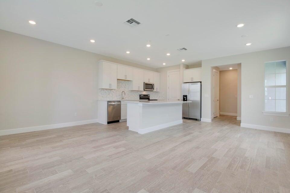 1875 Southeast Ocean Cove Way Stuart, FL 34996 - Photo 14 of 37 a view of kitchen with kitchen island wooden floor center island and stainless steel appliances