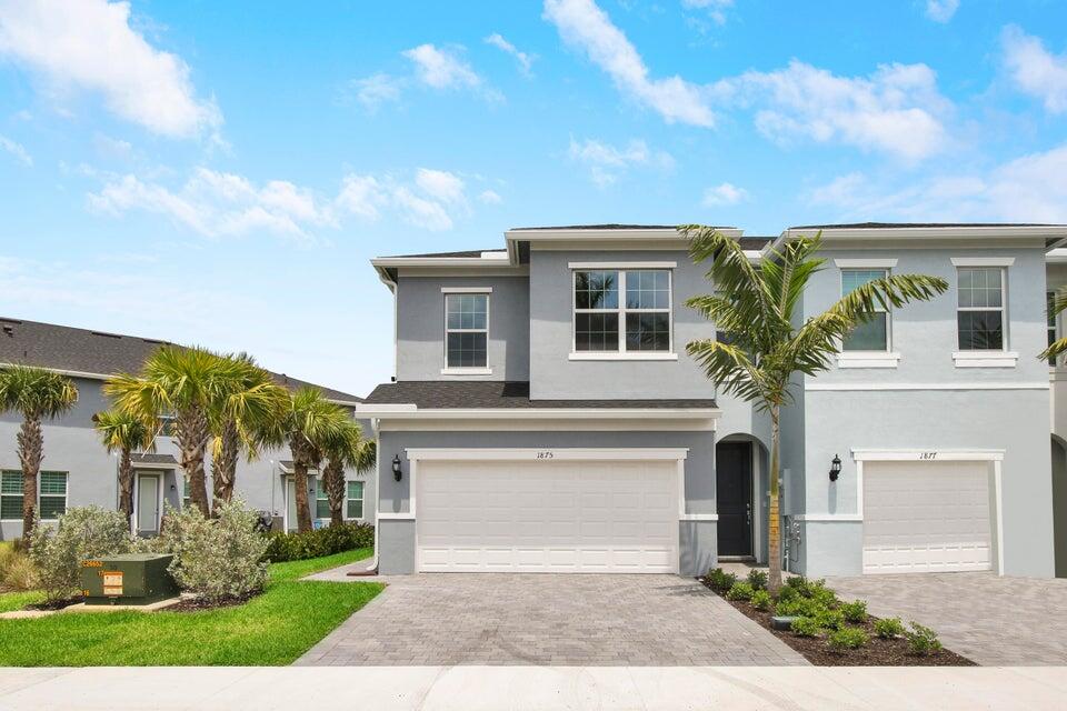 1875 Southeast Ocean Cove Way Stuart, FL 34996 - Photo 35 of 37 a front view of a house with a garden and plants