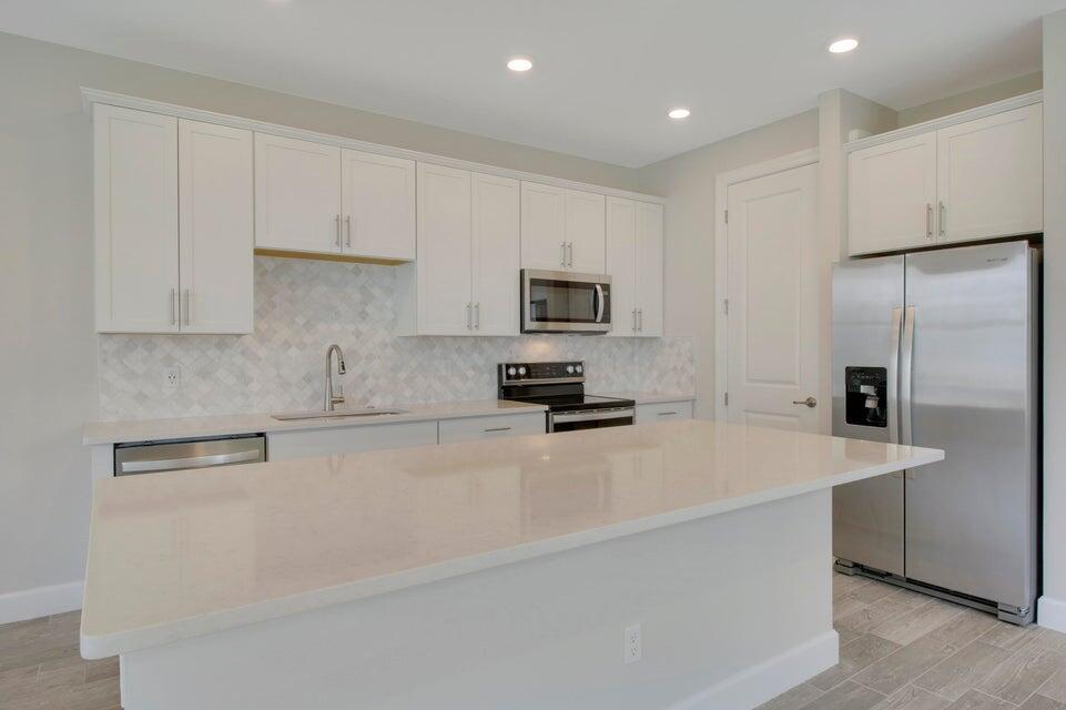 1875 Southeast Ocean Cove Way Stuart, FL 34996 - Photo 7 of 37 a kitchen with stainless steel appliances granite countertop a refrigerator a sink a stove a microwave and white cabinets