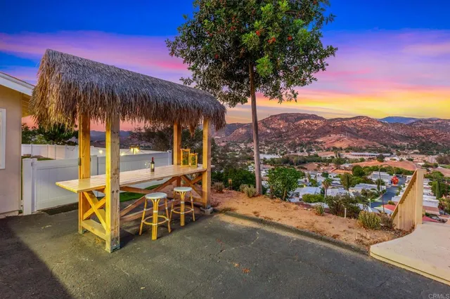 a view of a patio with a table and chairs under an umbrella