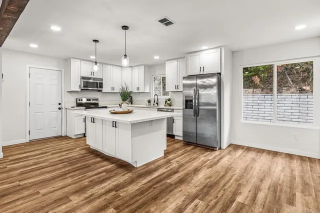 a kitchen with stainless steel appliances sink refrigerator and microwave