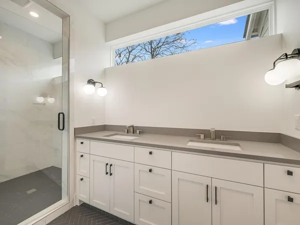 a bathroom with a granite countertop sink and white cabinets