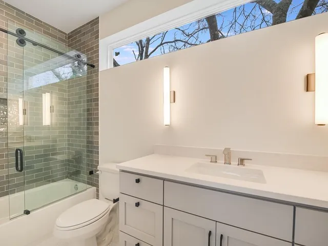 a bathroom with a sink a toilet and shower