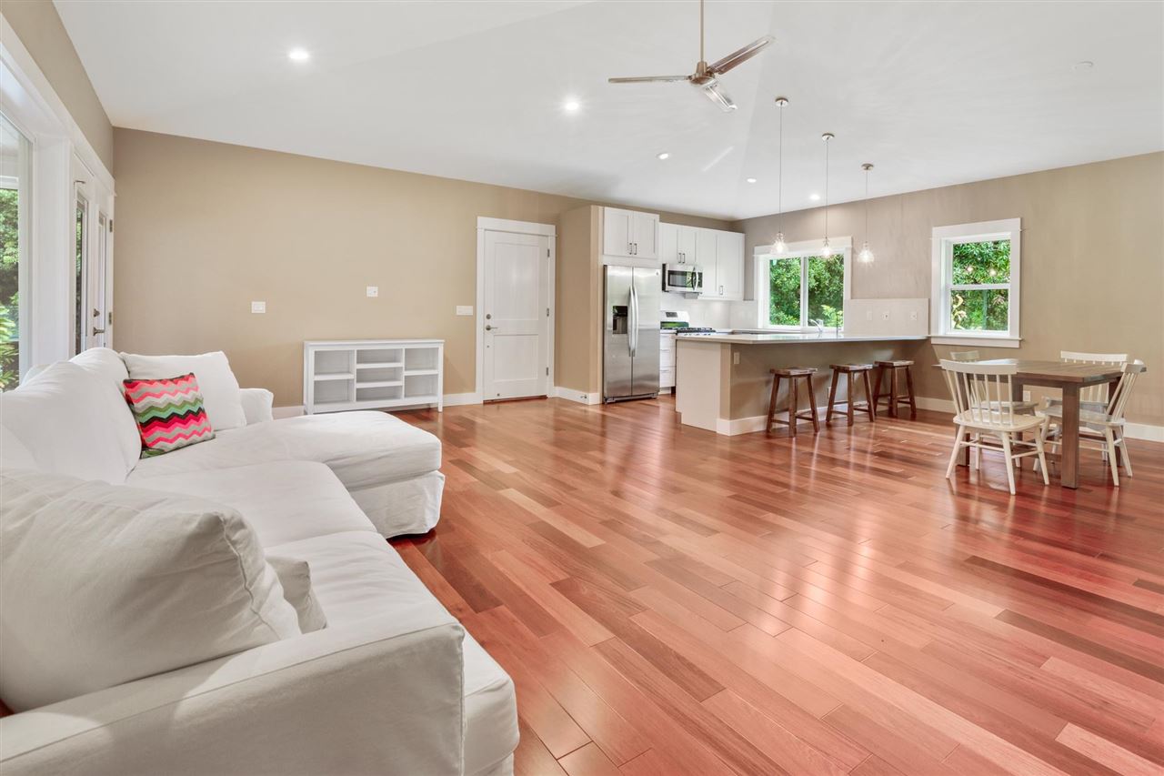927 Kokomo Road, Unit 1 Haiku, HI 96708 - Photo 9 of 30 a bedroom with furniture and wooden floor