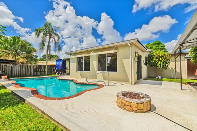 a view of a house with swimming pool and a yard