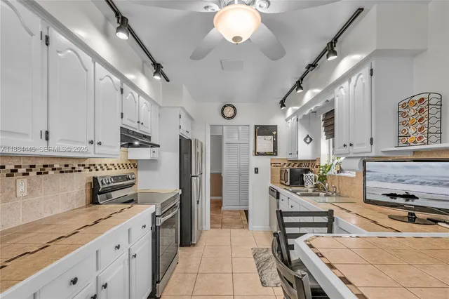 a kitchen with stainless steel appliances granite countertop a sink and cabinets