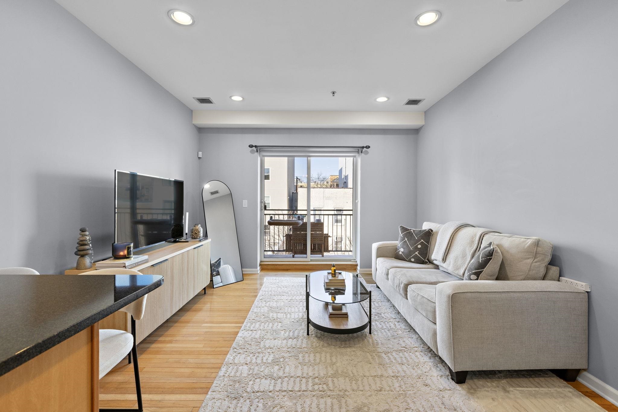 612 Adams Street, Unit 4 Hoboken, NJ 07030 - Photo 9 of 14 a living room with furniture and a flat screen tv