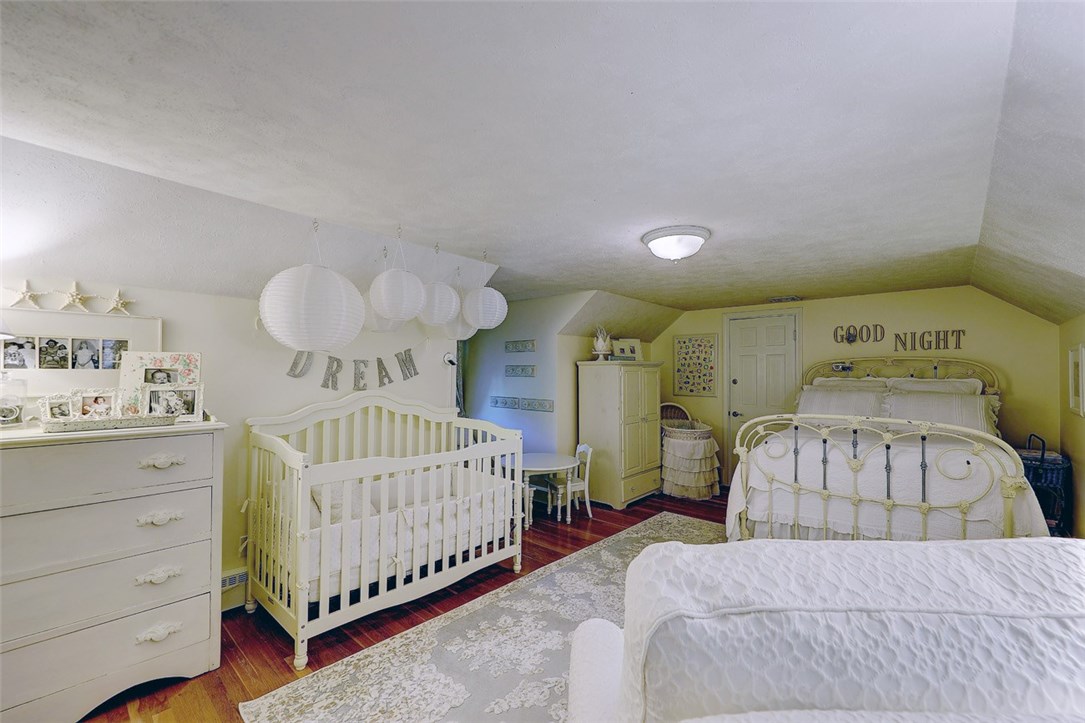 2894 Mendon Road Cumberland, RI 02864 - Photo 28 of 39 Second Floor Bedroom. 20' 2" X 19' 8". Faces both front and back. Door next to bed leads to spacious 2 walk-in attics. (13' 11" X 23' 7" and 15' 6" X 23' 7")