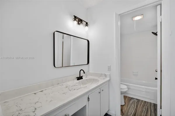 a bathroom with a granite countertop sink and a mirror
