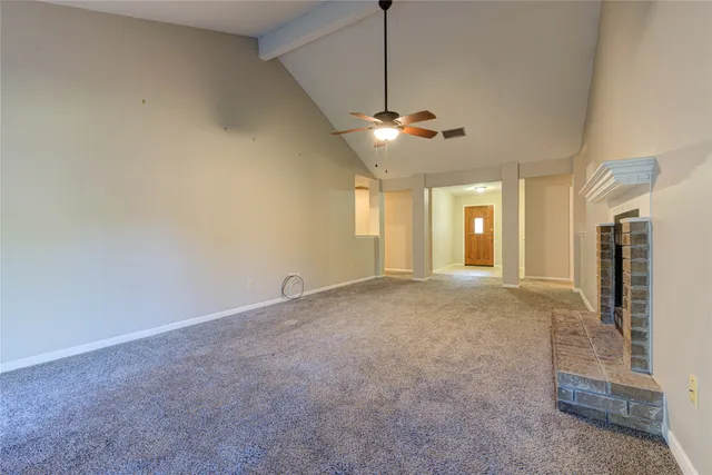 a view of empty room with fireplace and fan