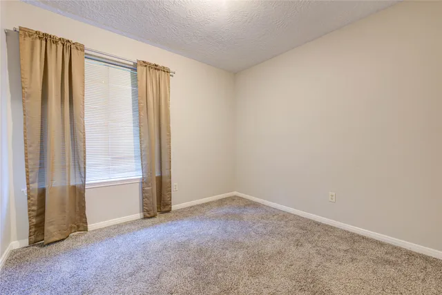 a bathroom with a granite countertop toilet sink and mirror