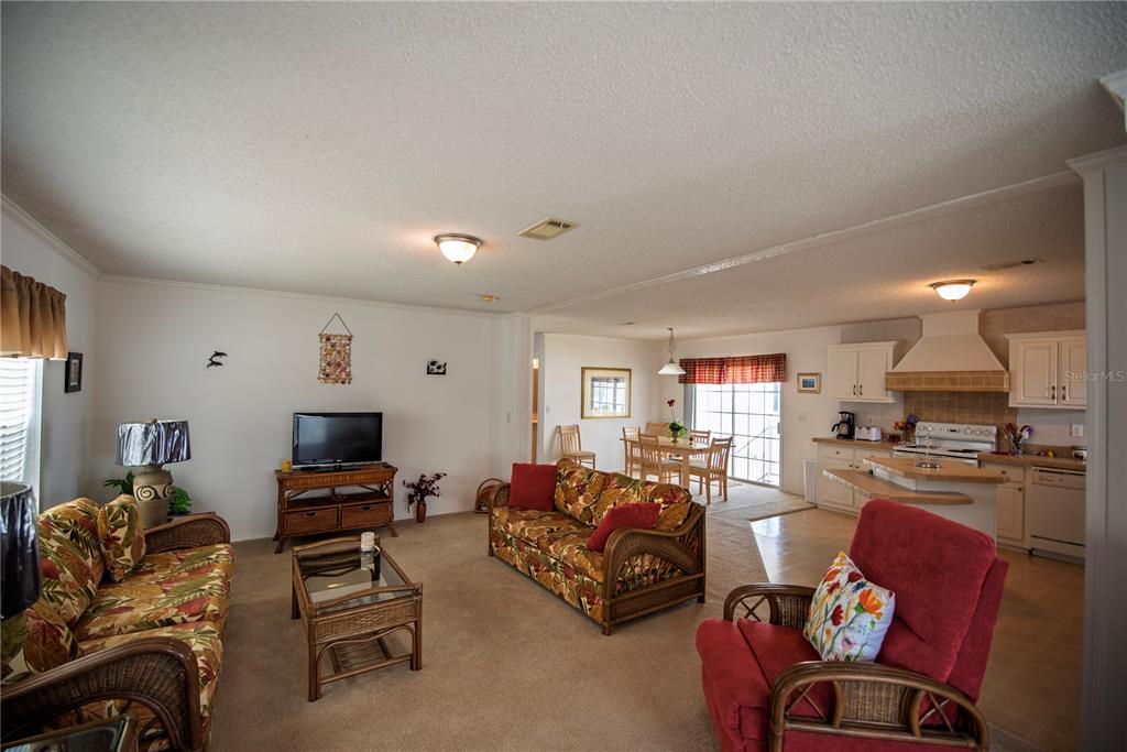 36 Freeman Avenue Punta Gorda, FL 33950 - Photo 10 of 27 a living room with furniture a flat screen tv and a refrigerator