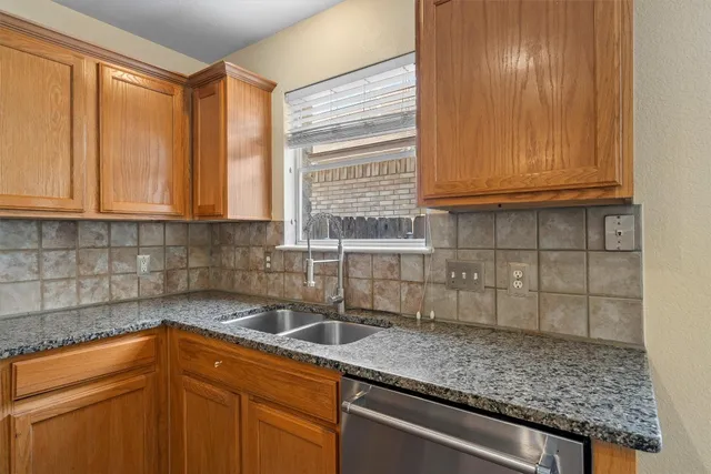 a kitchen with granite countertop a sink and cabinets