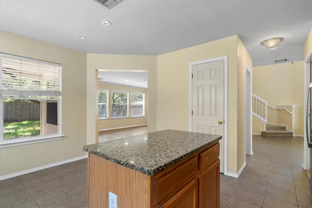 a bathroom with a granite countertop sink and a window