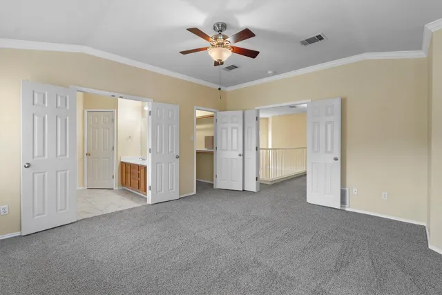 an empty room with closet and a ceiling fan