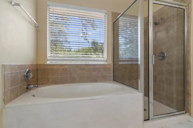 a white bath tub sitting next to a shower
