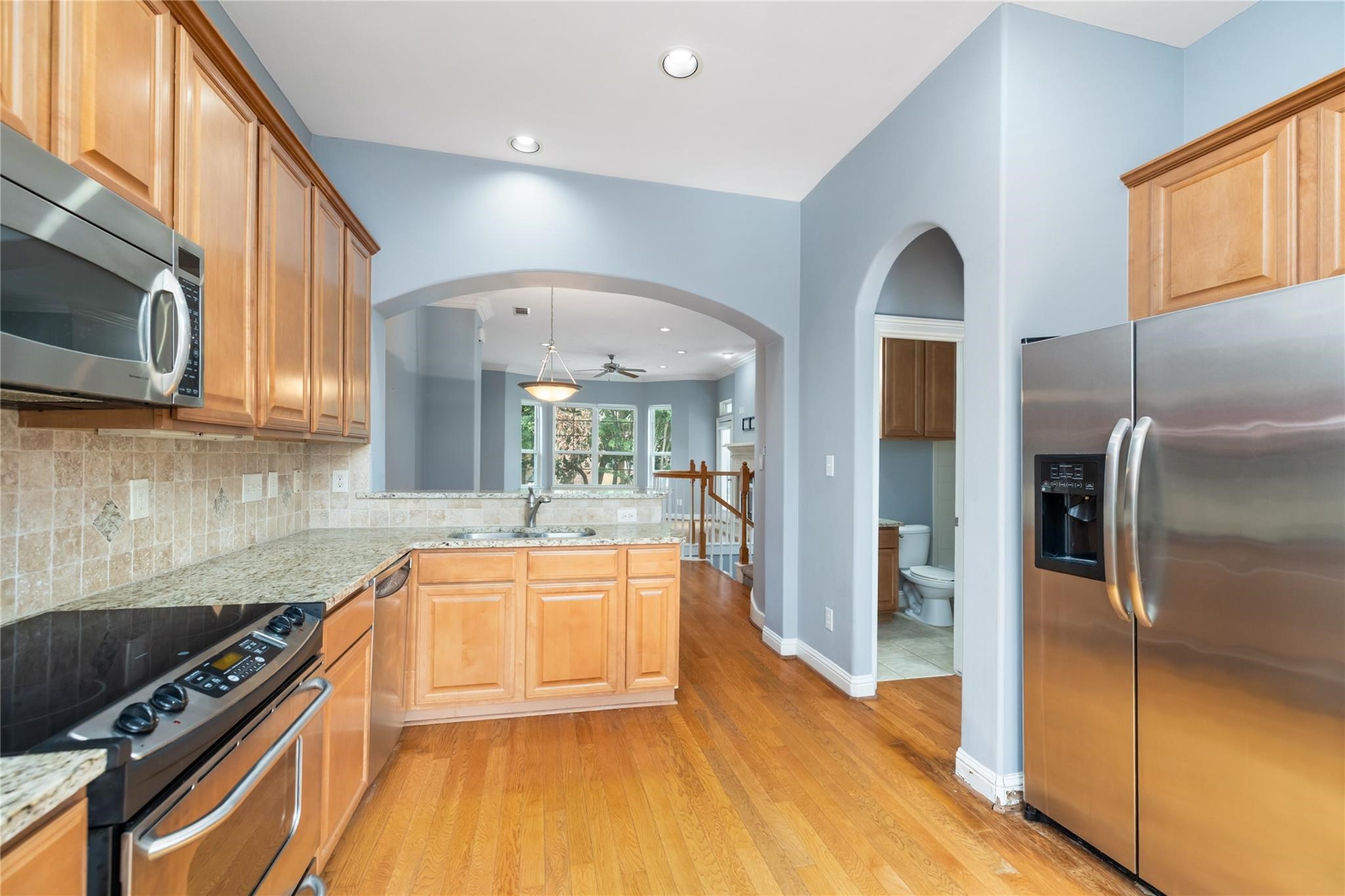 53 Versante Court Houston, TX 77070 - Photo 11 of 30 a kitchen with stainless steel appliances granite countertop a refrigerator a sink dishwasher a stove and white countertops with wooden floor