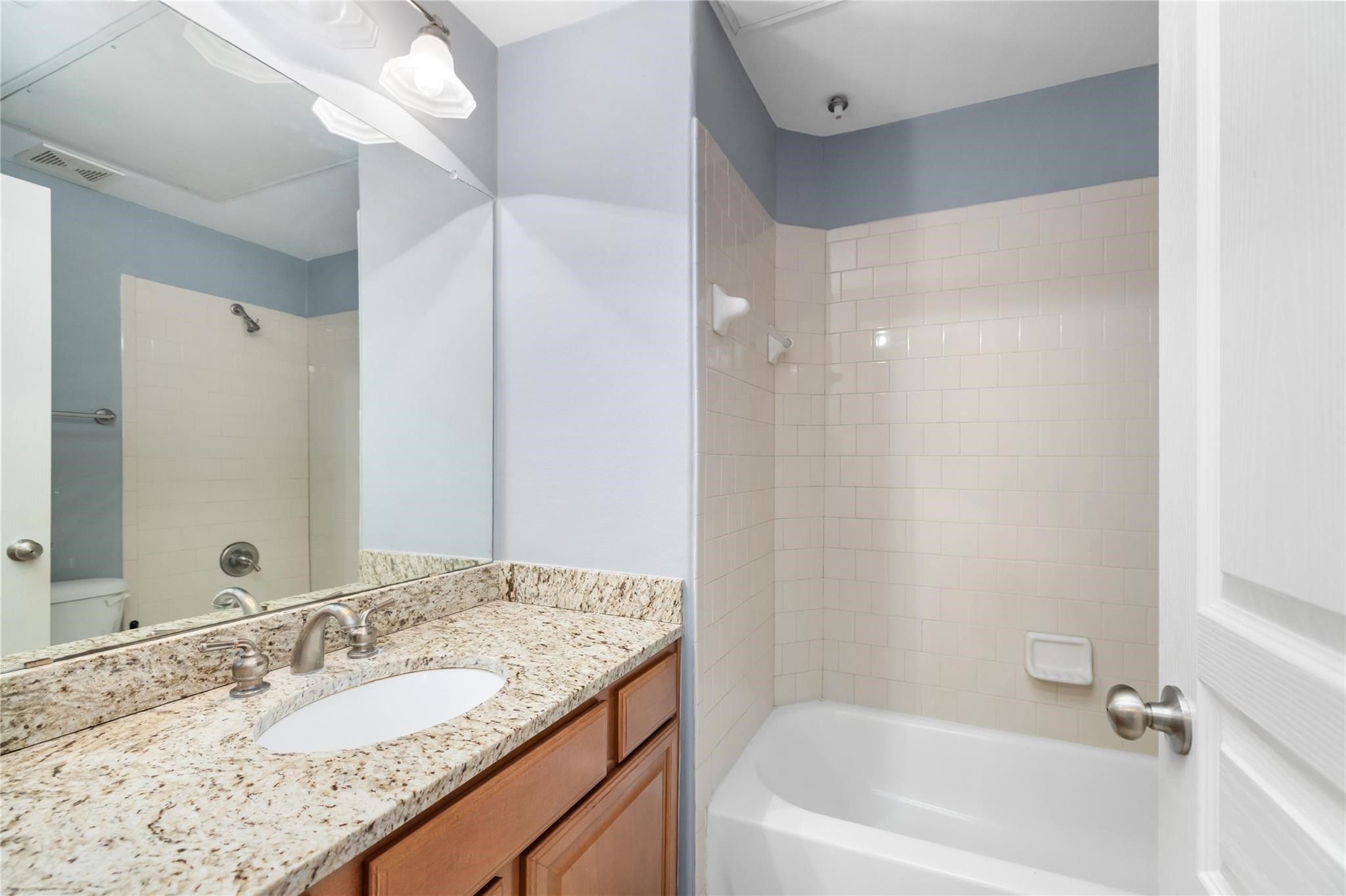 53 Versante Court Houston, TX 77070 - Photo 23 of 30 a bathroom with a granite countertop sink and a mirror