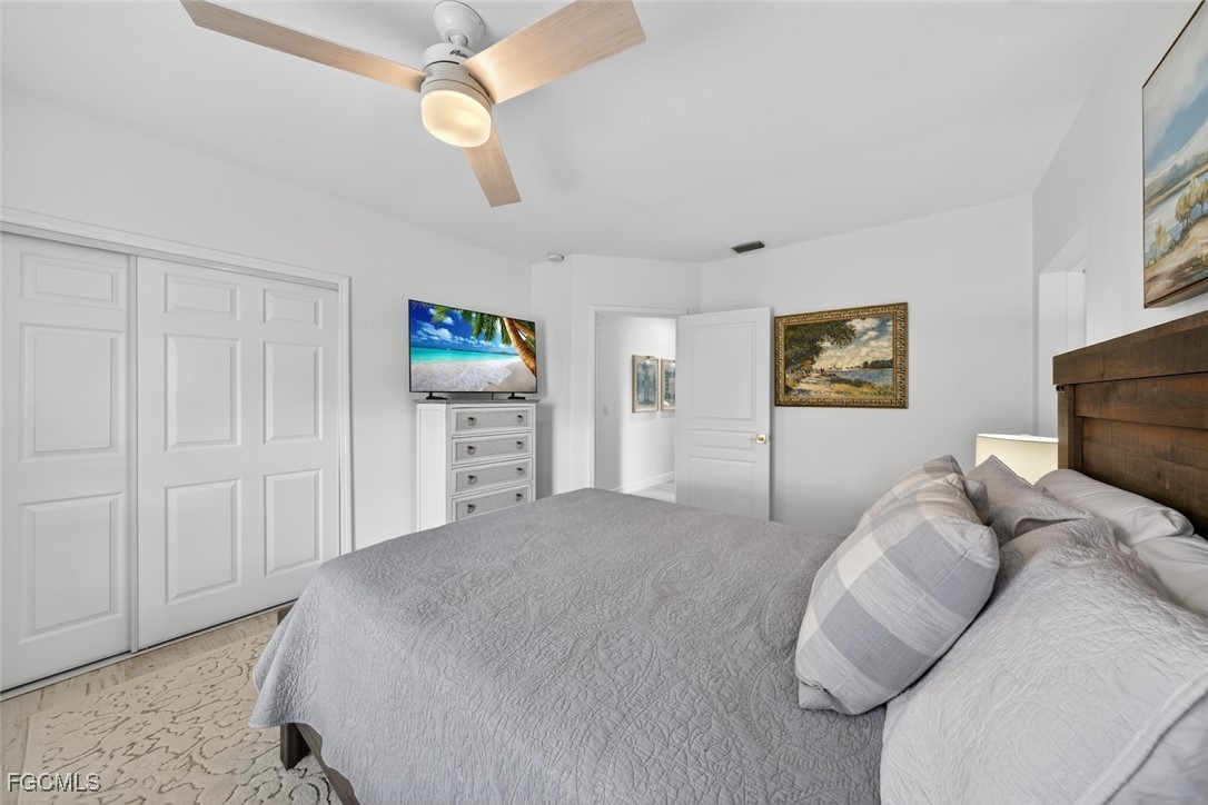 13570 Harbour Ridge Drive Fort Myers, FL 33908 - Photo 32 of 50 a bedroom with a bed and a chandelier