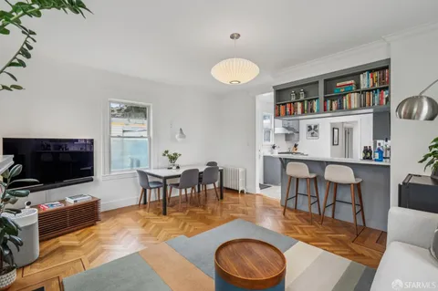 a dining room with kitchen island a table chairs and a shelf