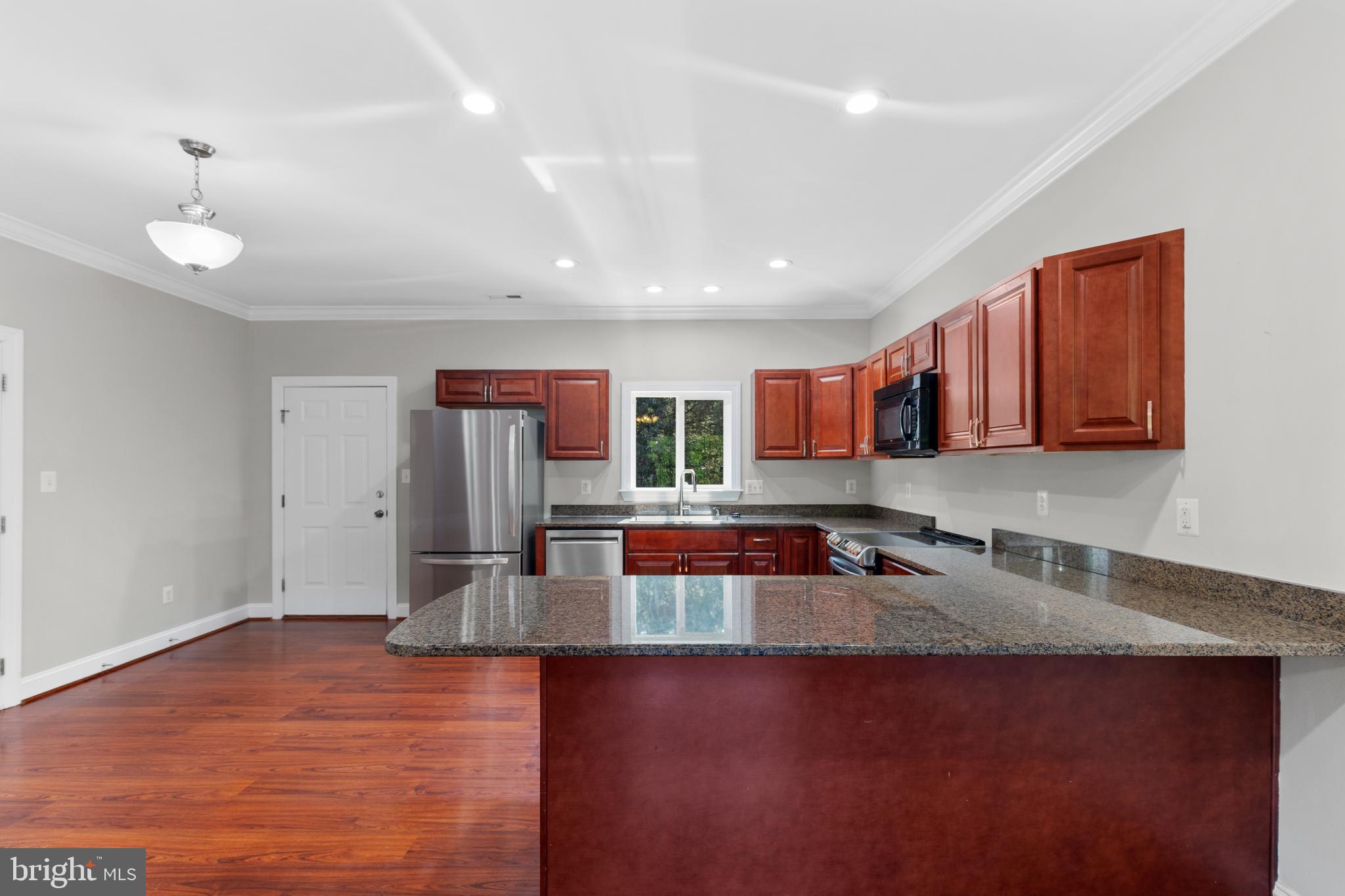 16665 Three Notch Road Ridge, MD 20680 - Photo 11 of 38 a kitchen with stainless steel appliances granite countertop a sink dishwasher stove top oven and cabinets with wooden floor