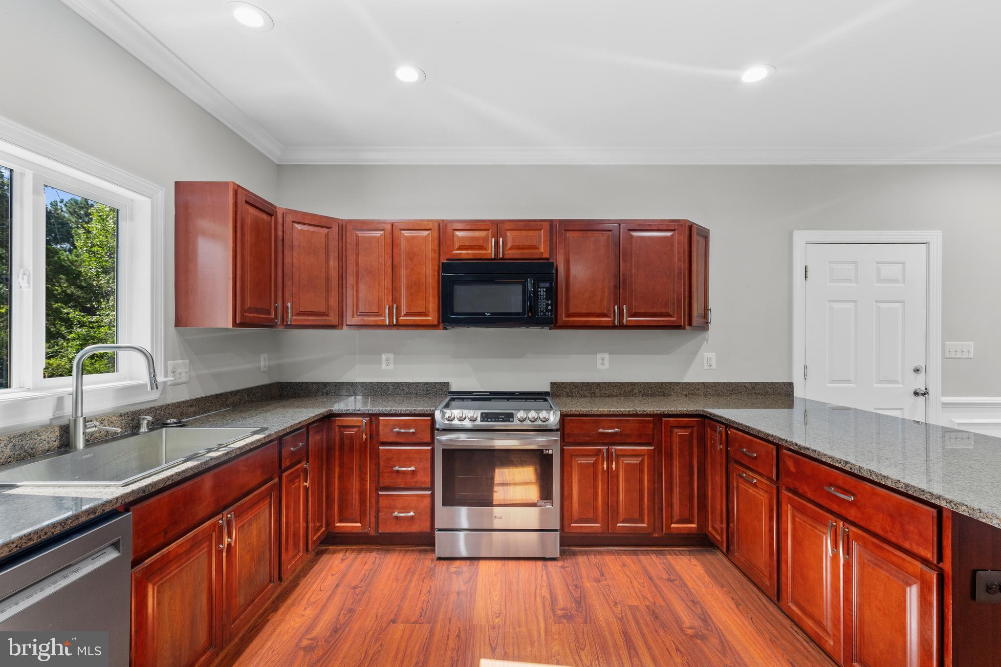 16665 Three Notch Road Ridge, MD 20680 - Photo 12 of 38 a kitchen with stainless steel appliances granite countertop wooden cabinets a sink and dishwasher a stove with wooden floor