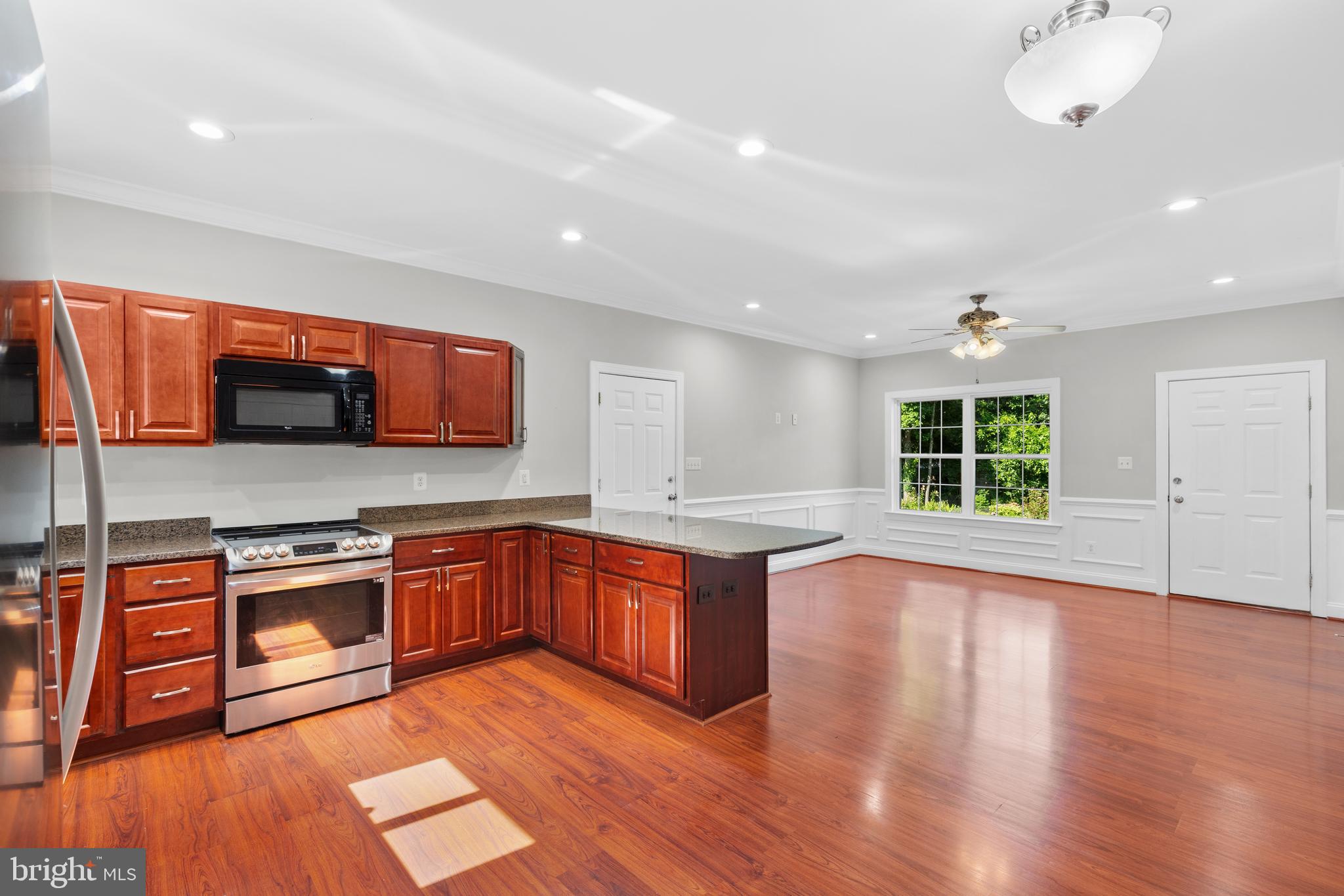 16665 Three Notch Road Ridge, MD 20680 - Photo 13 of 38 a large kitchen with stainless steel appliances granite countertop a stove and a wooden floors
