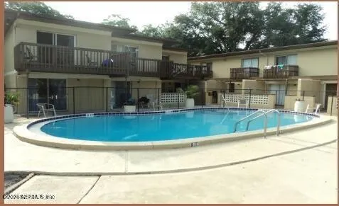 a view of backyard with swimming pool and seating space