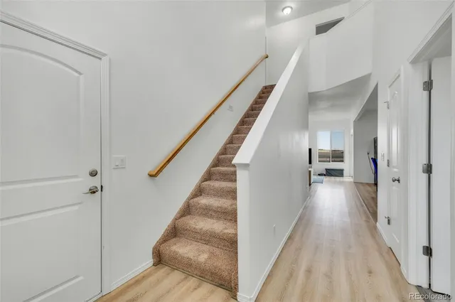 a view of a hallway with wooden floor and staircase