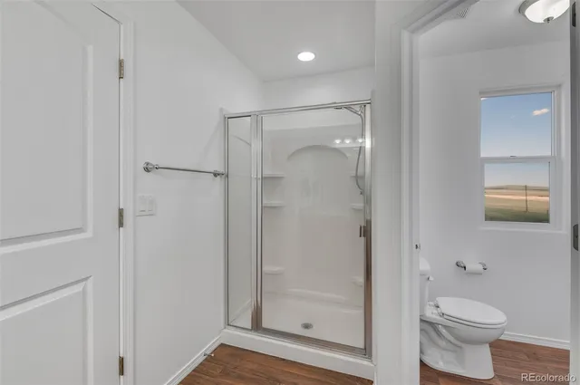 a bathroom with a granite countertop toilet and a shower