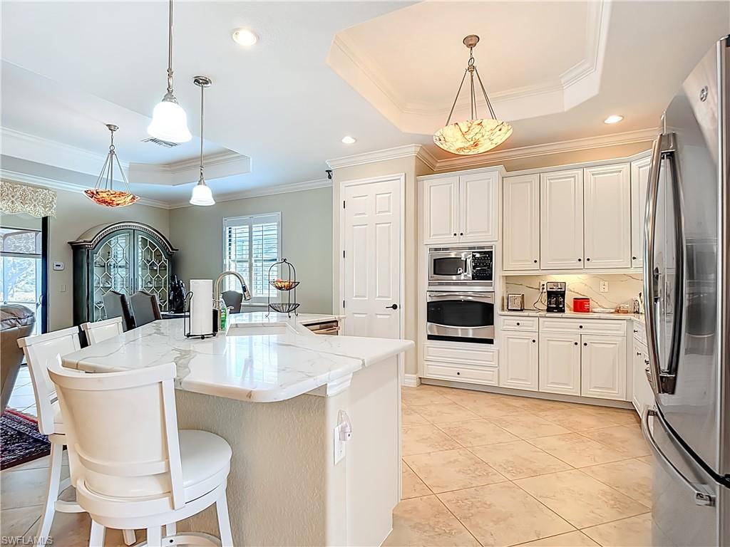 9250 Veneto Place Naples, FL 34113 - Photo 16 of 50 a large kitchen with kitchen island a large counter space appliances and cabinets
