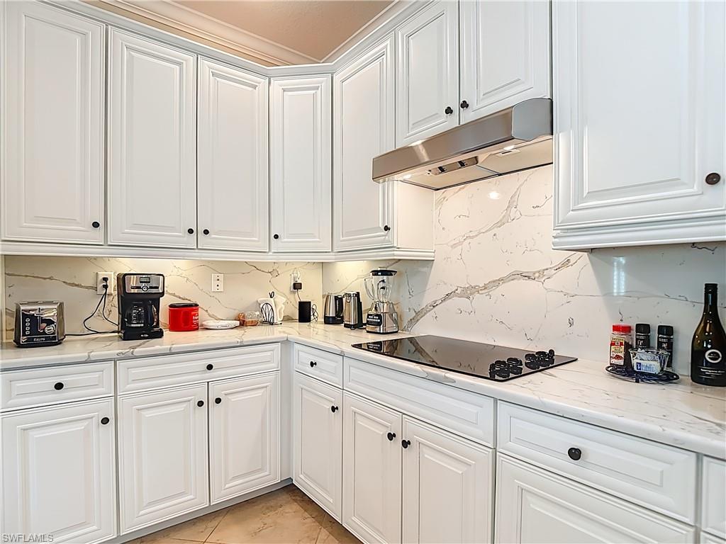9250 Veneto Place Naples, FL 34113 - Photo 17 of 50 a kitchen with white cabinets and white appliances