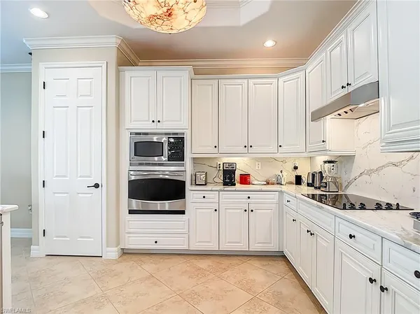 a kitchen with white cabinets and white appliances